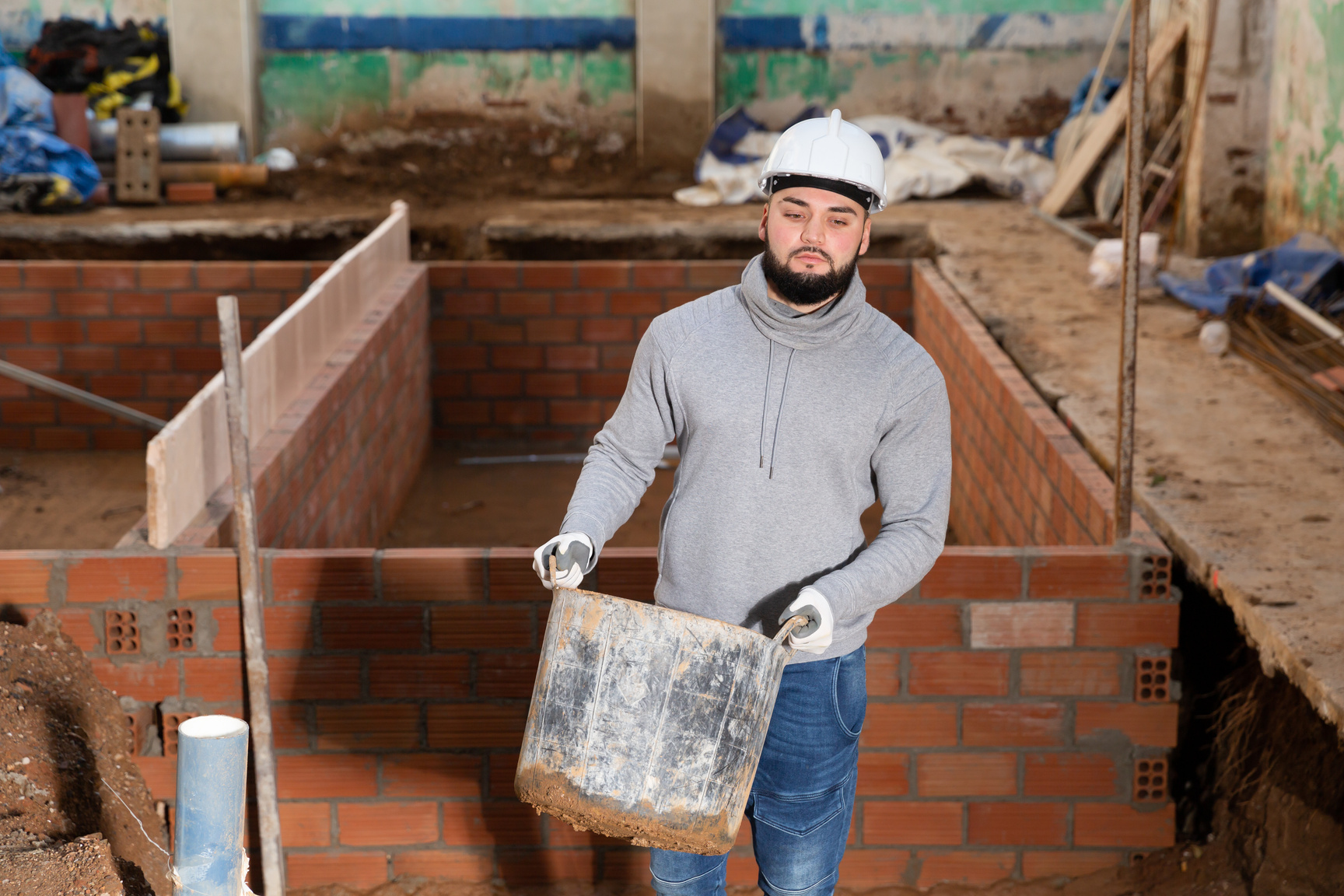 Contractor carrying bucket with cement mortar
